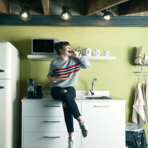 Beautiful girl eating pizza in a modern kitchen